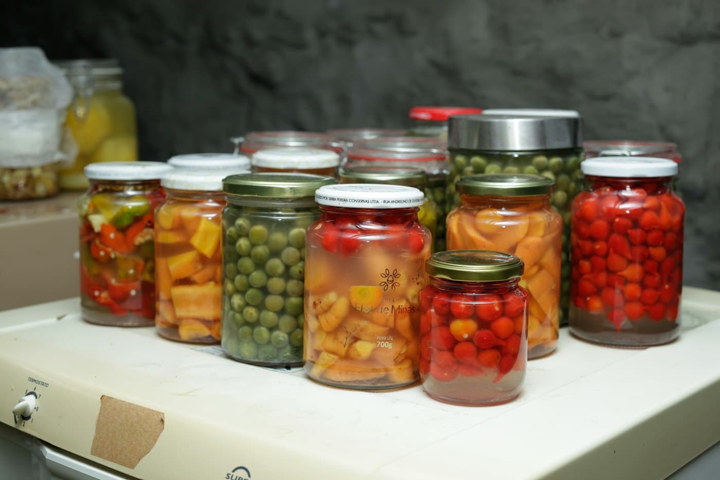 Gläser mit eingelegtem Gemüse, Paprika und Erbsen