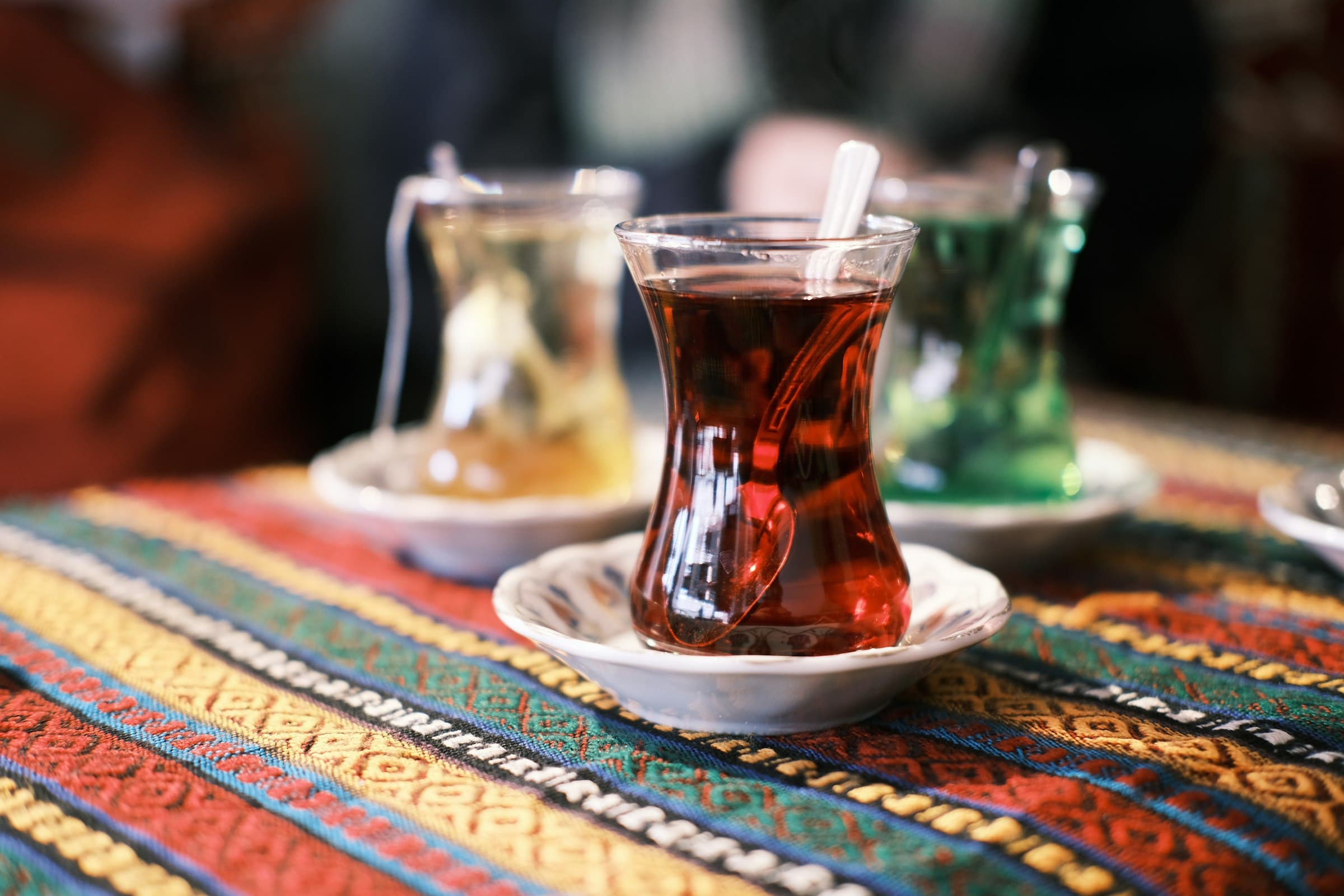 Türkischer Tee im Tulpenglas auf einer bunt gemusterten Tischdecke