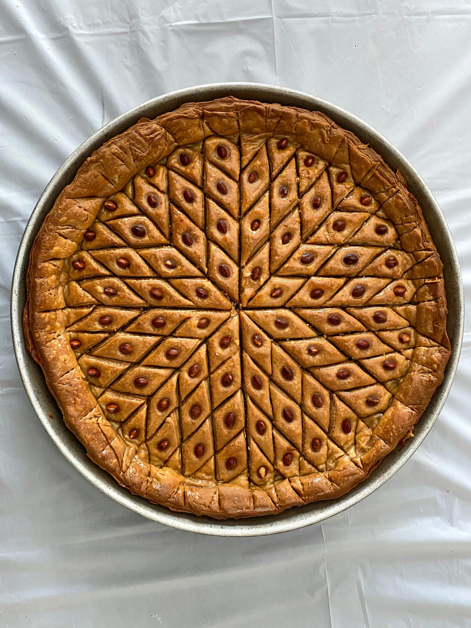 Rundes Blech mit selbst gemachter, rautenförmig geschnittener Baklava