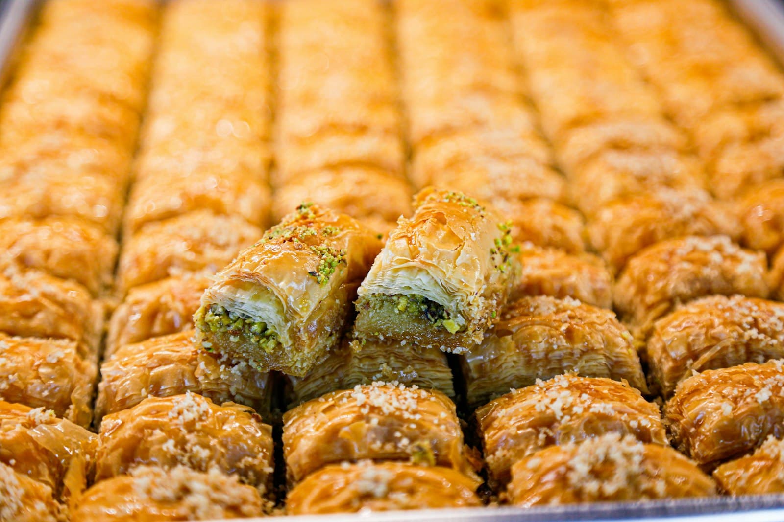Reihen von goldbrauner Baklava mit Pistazien auf einem Blech